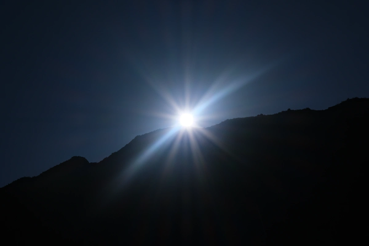 Noon time sun behind the mountains