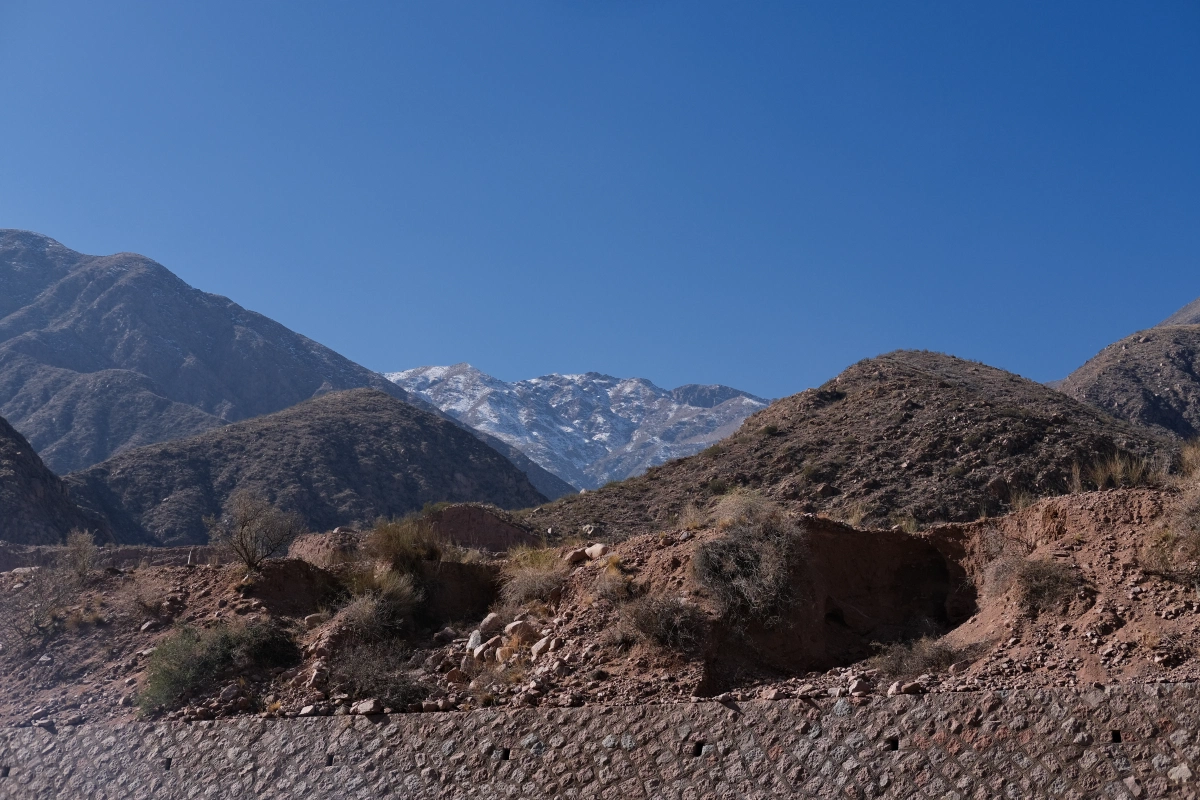 The snowy mountains behind are apparently the younger mountains... Hence they are higher, and snowier...